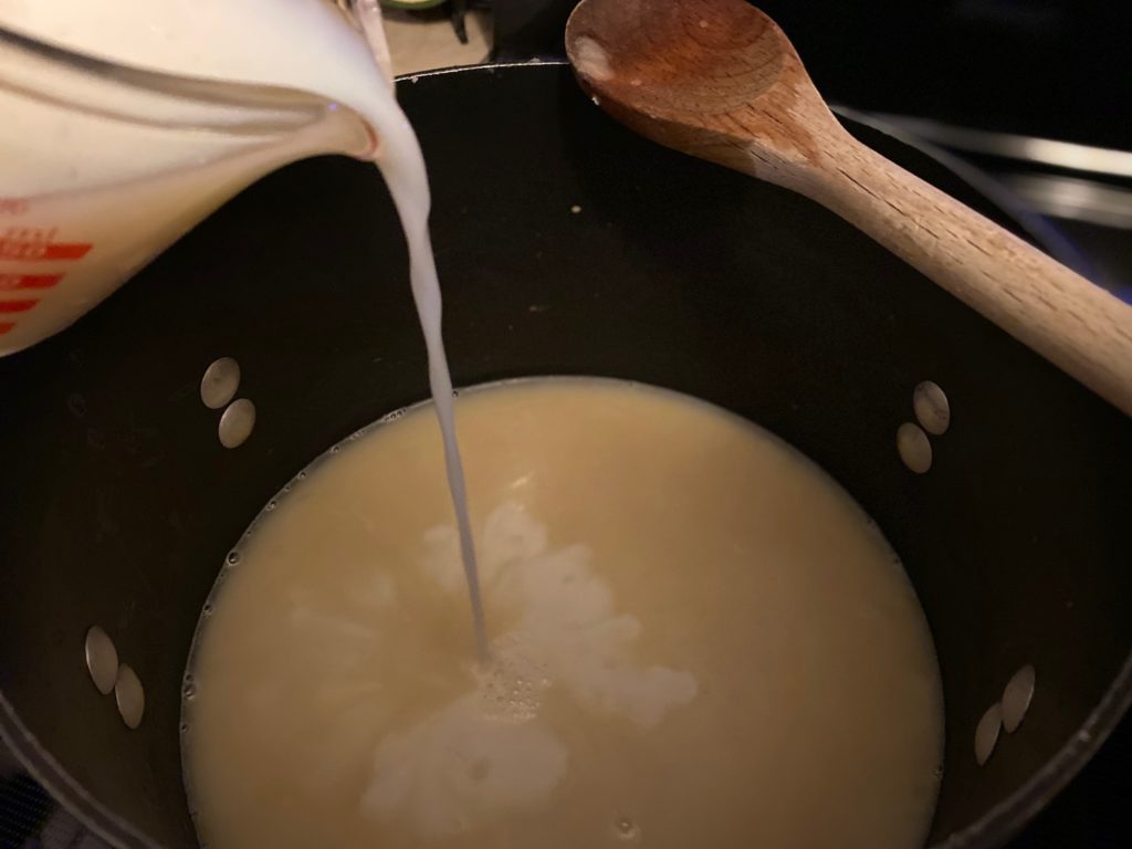 adding milk to soup